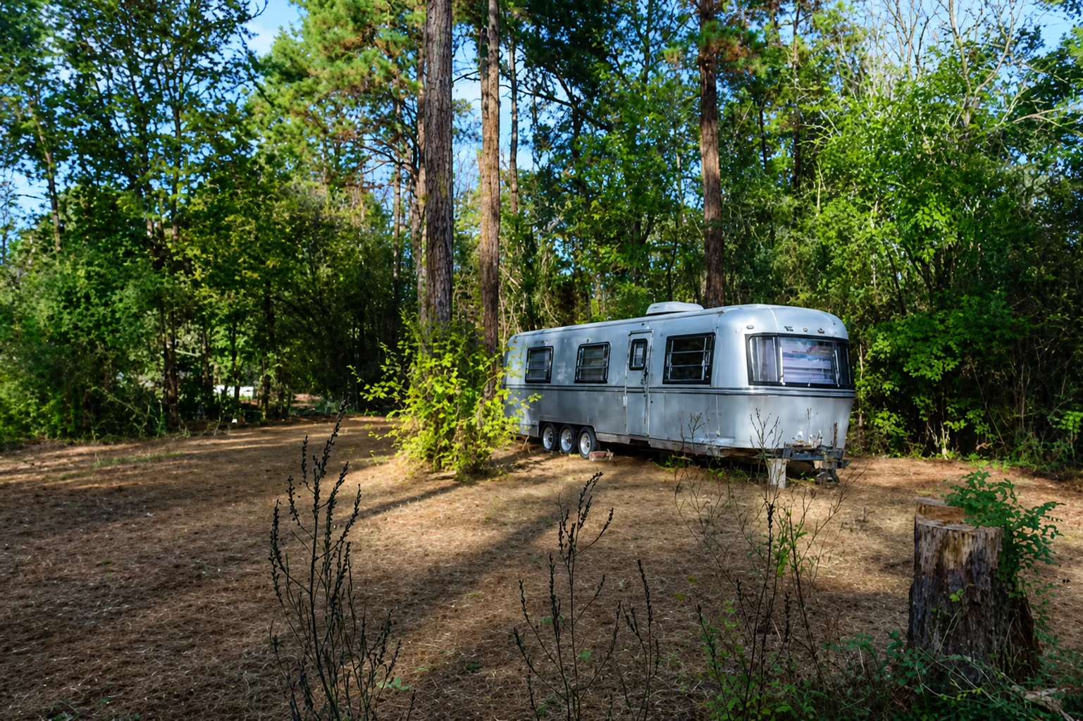 The silver Soulful Stay RV in its woodland campground setting