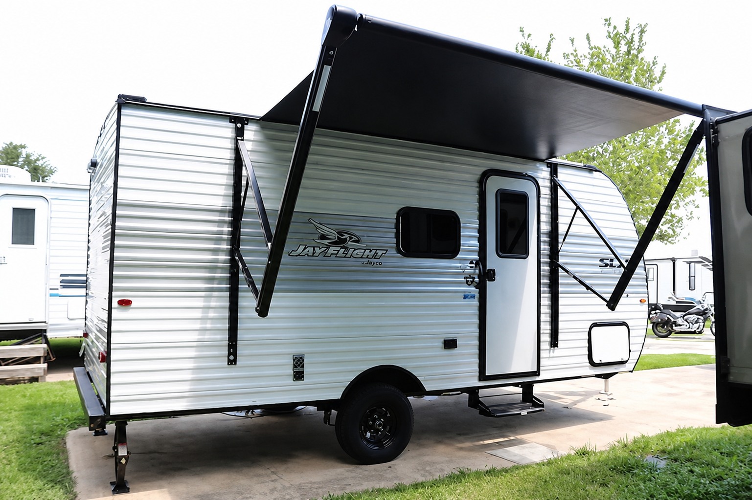 CampCation JayFlight travel trailer beneath its extended awning